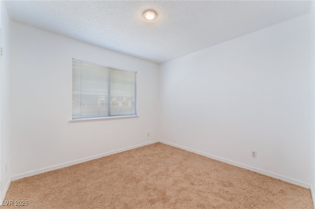 empty room featuring a textured ceiling and light carpet