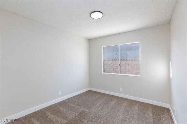 carpeted empty room with a textured ceiling