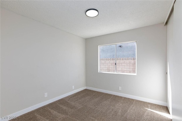 unfurnished room with a textured ceiling and carpet