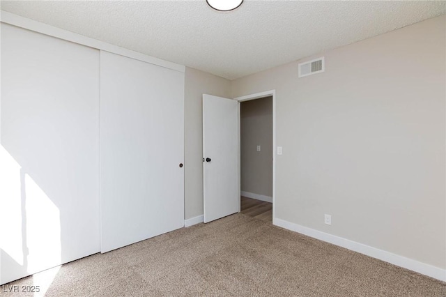 empty room featuring a textured ceiling and carpet floors