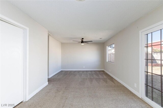 carpeted spare room featuring ceiling fan and a textured ceiling