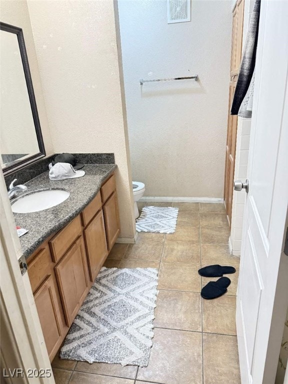 bathroom with tile patterned floors, vanity, and toilet