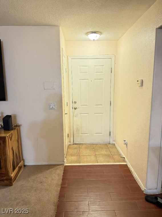 doorway with hardwood / wood-style floors and a textured ceiling