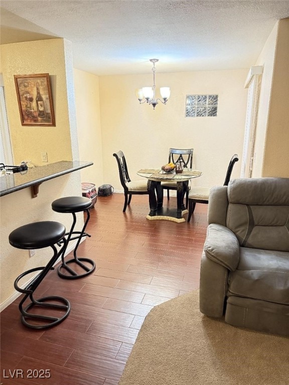 living room with a textured ceiling, a notable chandelier, and hardwood / wood-style flooring