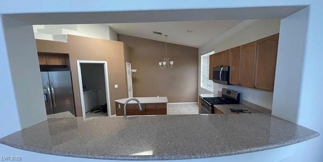 kitchen featuring kitchen peninsula, stainless steel appliances, an inviting chandelier, and sink