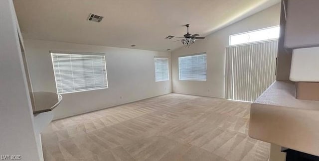 interior space featuring ceiling fan, light carpet, and lofted ceiling