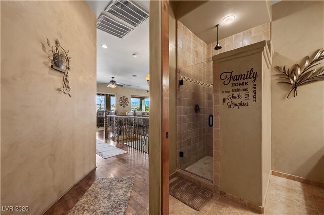 bathroom featuring ceiling fan and a shower with shower door