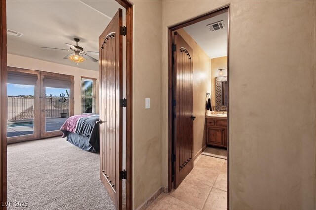 hall featuring light colored carpet and sink