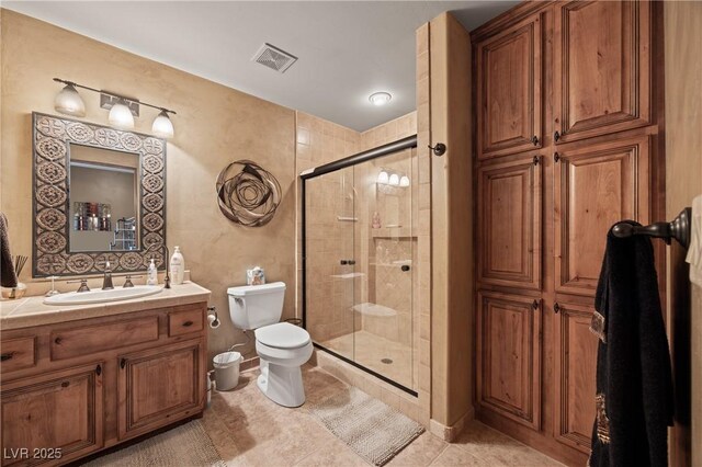 bathroom featuring tile patterned flooring, vanity, an enclosed shower, and toilet