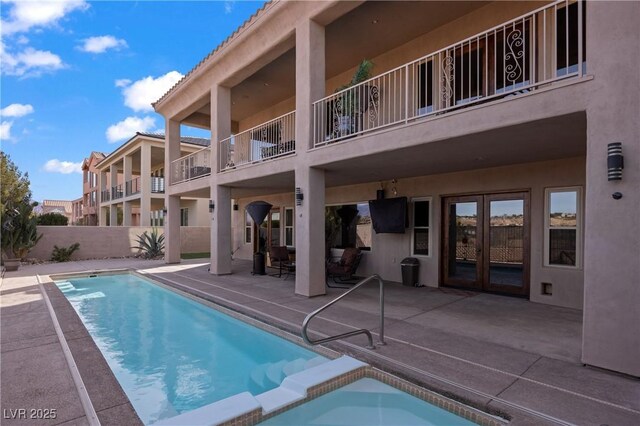 view of pool featuring a patio area, an in ground hot tub, and french doors