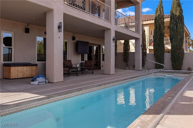 view of swimming pool with a patio area and a hot tub