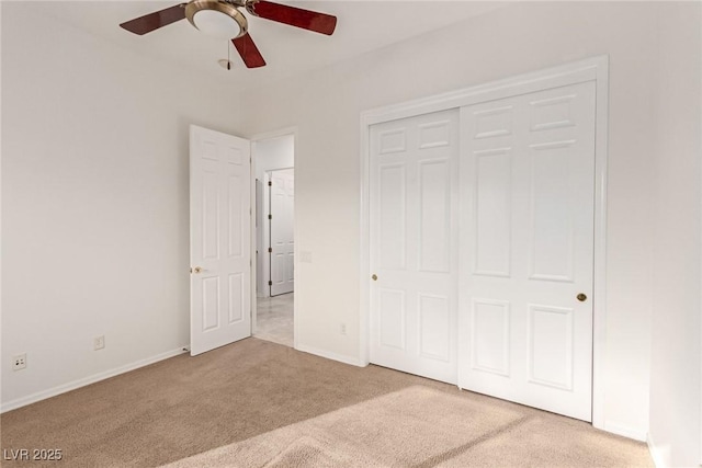 unfurnished bedroom with ceiling fan, a closet, and light carpet