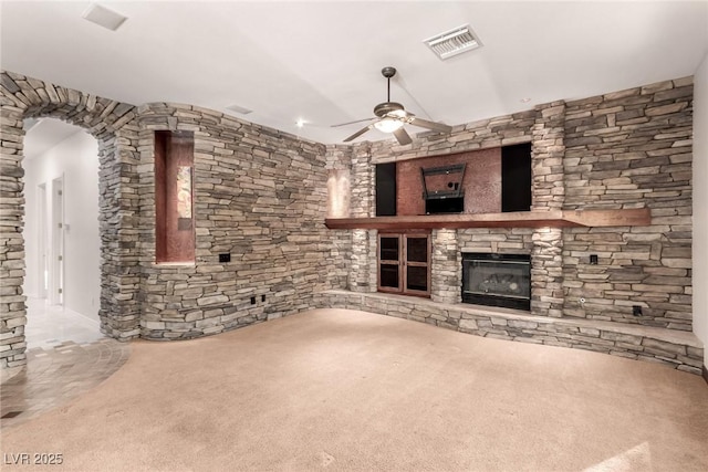 unfurnished living room featuring ceiling fan, a fireplace, and carpet floors