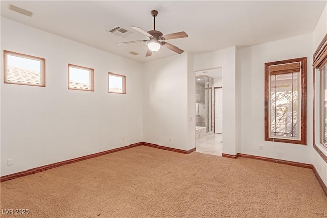 empty room featuring ceiling fan and light colored carpet