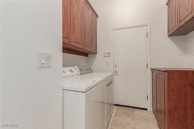 laundry area with washing machine and dryer and cabinets