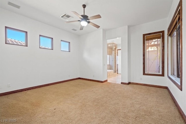 spare room with a wealth of natural light, carpet, visible vents, and baseboards