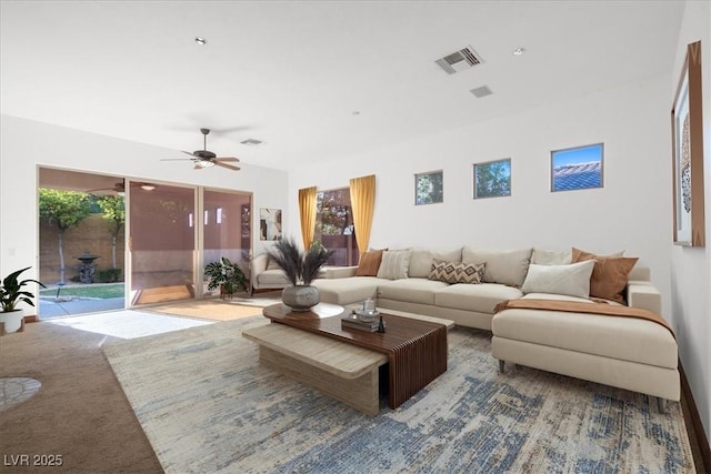 living area featuring a ceiling fan, visible vents, and carpet flooring