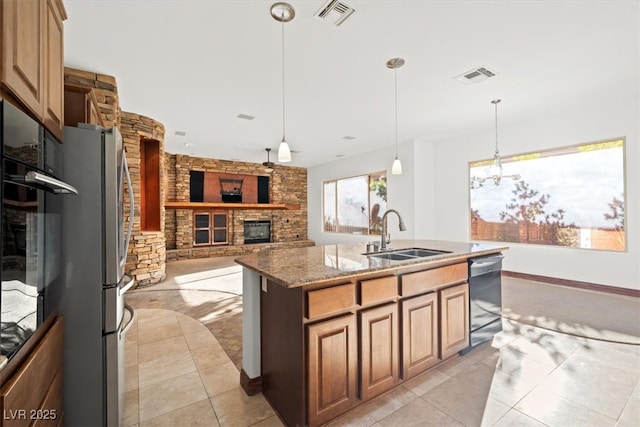 kitchen featuring a fireplace, visible vents, a sink, and dishwashing machine