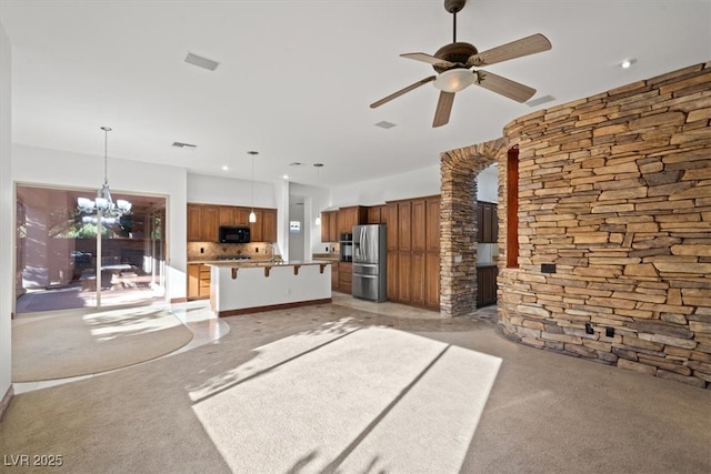 unfurnished living room with visible vents, a sink, and ceiling fan with notable chandelier