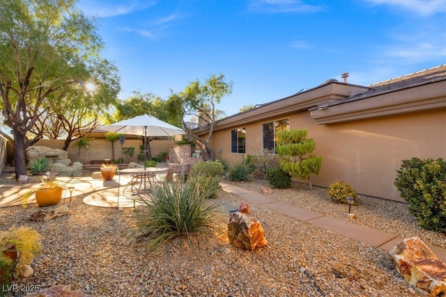 rear view of house with a patio area and stucco siding