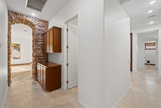 hallway with visible vents, arched walkways, and recessed lighting