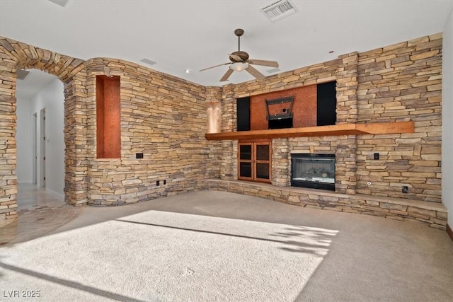 unfurnished living room featuring ceiling fan, a fireplace, and visible vents