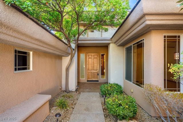 view of exterior entry with stucco siding