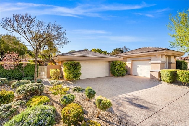 prairie-style house with concrete driveway, an attached garage, and stucco siding