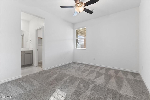 spare room featuring ceiling fan and light colored carpet