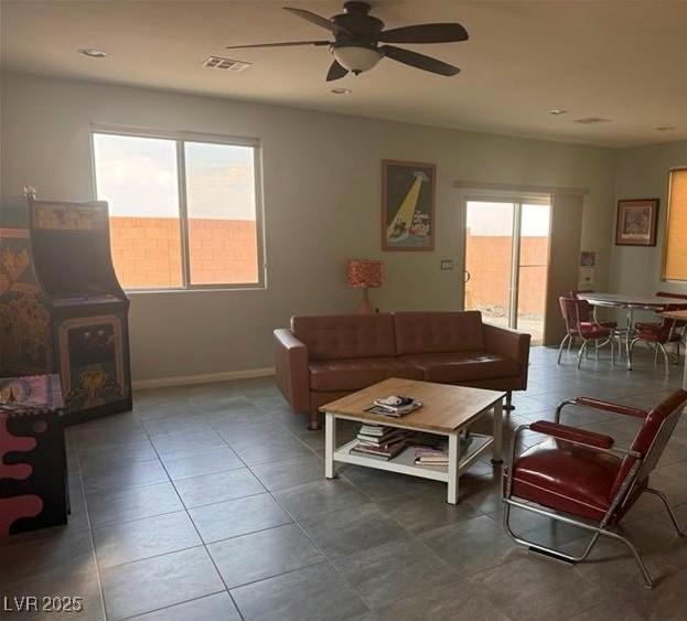 living room featuring ceiling fan and a healthy amount of sunlight