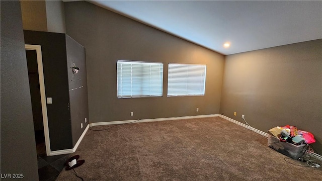 carpeted spare room with lofted ceiling