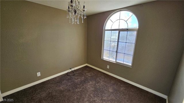 spare room featuring a chandelier and carpet floors