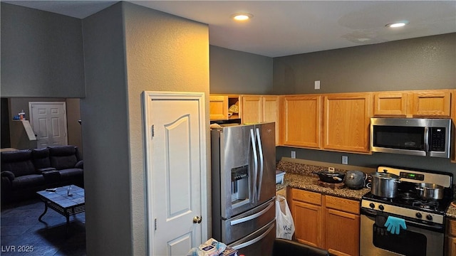 kitchen featuring dark stone countertops and appliances with stainless steel finishes