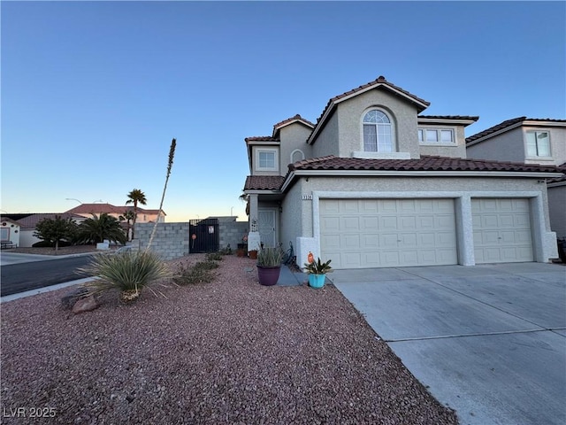 view of front of property with driveway, an attached garage, a tiled roof, and stucco siding