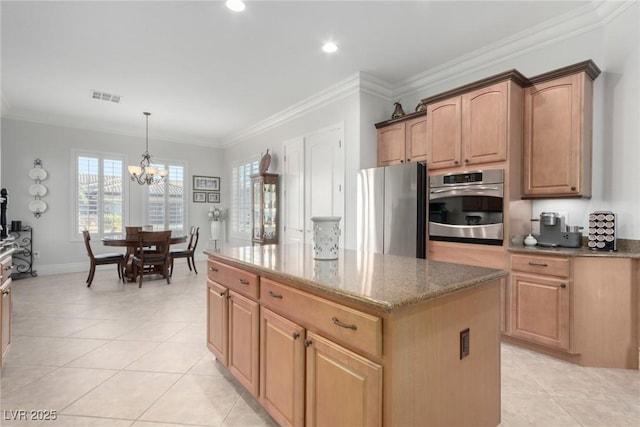 kitchen with a center island, stainless steel appliances, crown molding, and a notable chandelier