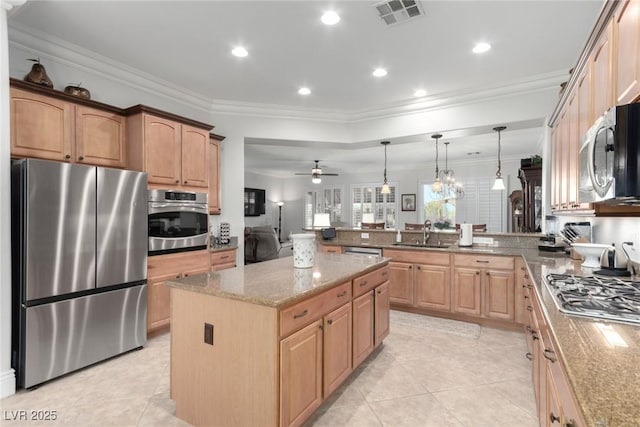 kitchen with a center island, ceiling fan, appliances with stainless steel finishes, decorative light fixtures, and kitchen peninsula