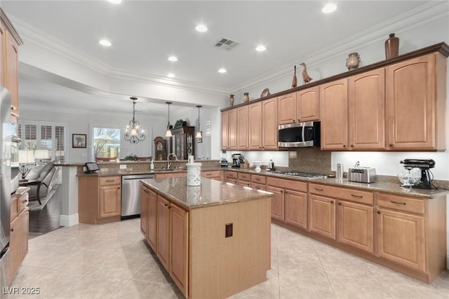 kitchen featuring sink, stainless steel appliances, kitchen peninsula, dark stone counters, and decorative light fixtures