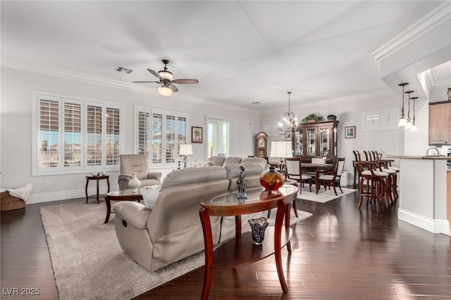 living room featuring ceiling fan with notable chandelier, crown molding, and dark wood-type flooring