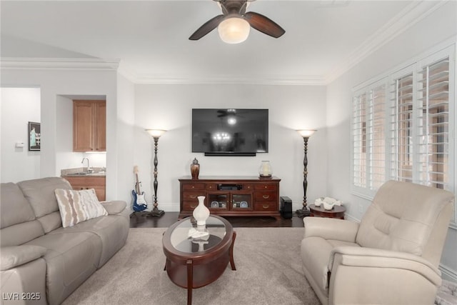 living room featuring hardwood / wood-style flooring, ceiling fan, crown molding, and sink