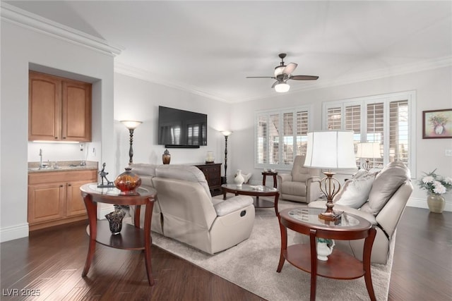 living room featuring dark wood-type flooring, ceiling fan, crown molding, and sink