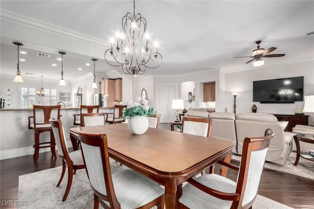 dining area featuring dark hardwood / wood-style floors, crown molding, and ceiling fan with notable chandelier