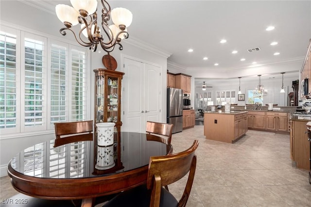 tiled dining space featuring ceiling fan with notable chandelier, sink, and crown molding