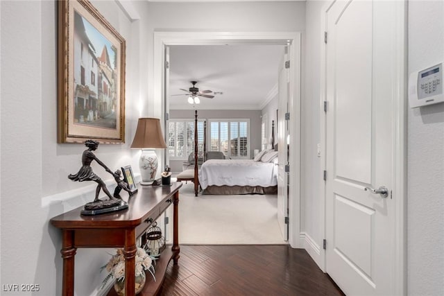 interior space featuring ceiling fan, ornamental molding, and dark wood-type flooring