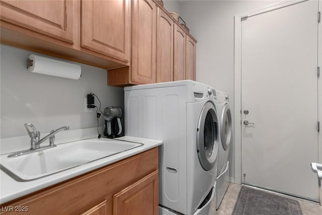 laundry area featuring washer and clothes dryer, cabinets, and sink