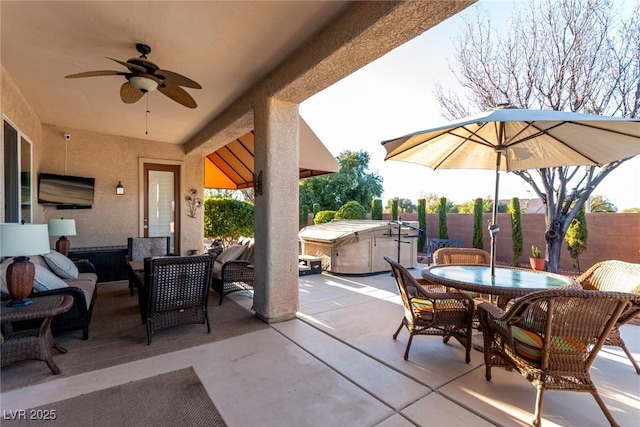 view of patio with outdoor lounge area, ceiling fan, and a hot tub