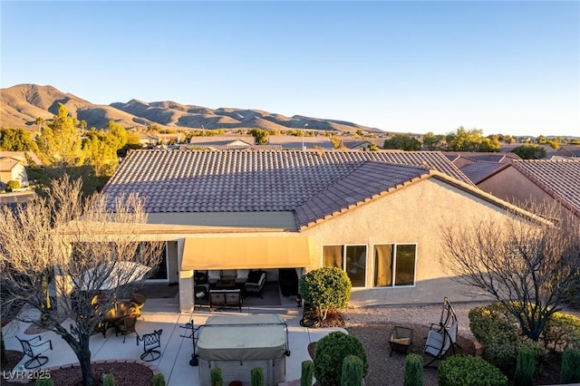 back of house with a mountain view and a patio