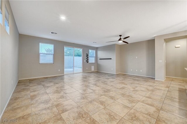 empty room with ceiling fan and light tile patterned flooring