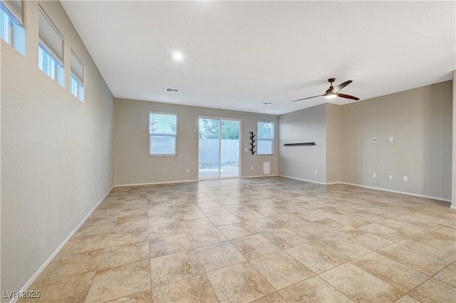 empty room with ceiling fan and light tile patterned floors