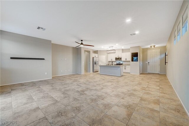 unfurnished living room with ceiling fan