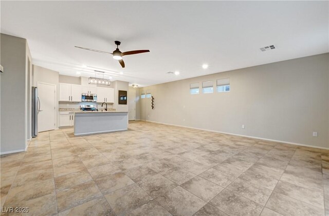 unfurnished living room with ceiling fan